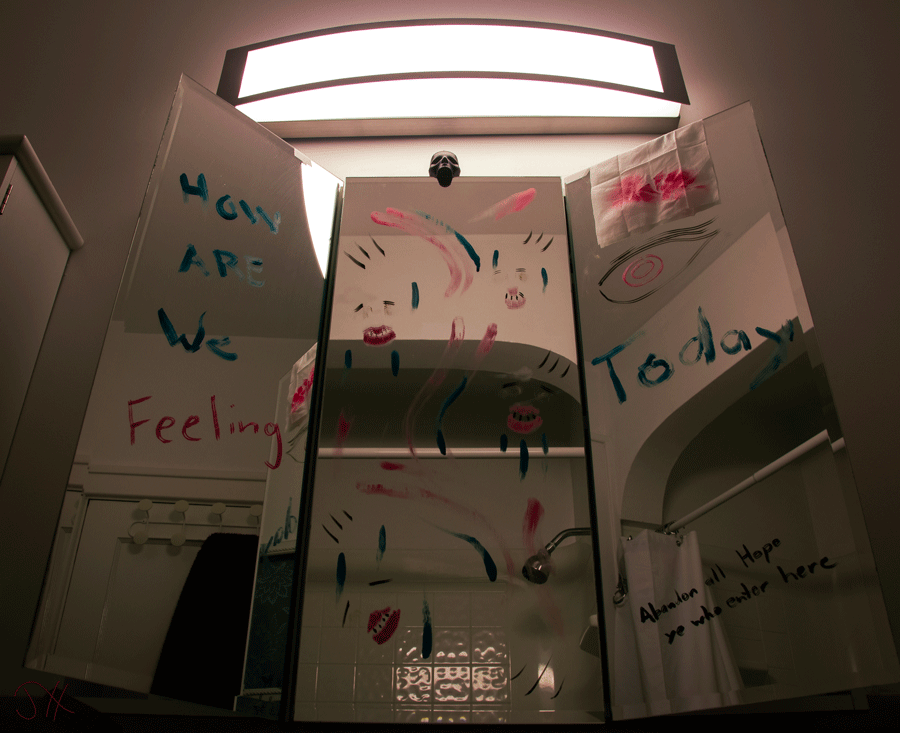 A bathroom mirror with graffiti scrawled across it using makeup. A small skull sits on top.